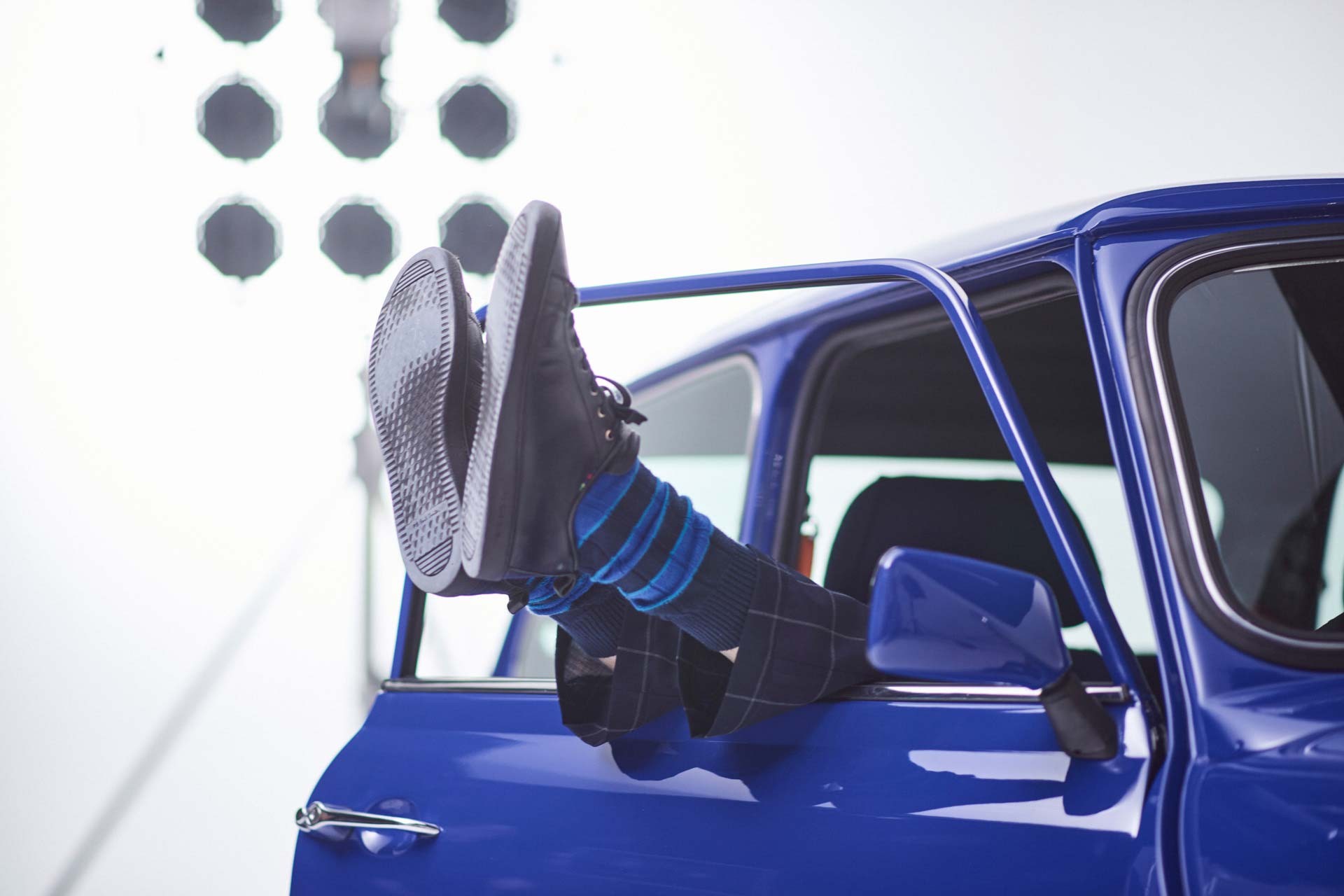 Paul Smith stretches his feet out of the lowered window of his MINI Recharged model.